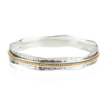A two-tone (silver and gold) Aura Halo Spinning Bangle bracelet . Mixed Metal Spinning Bangle