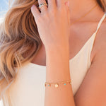 Gold charm bracelet wit gold hammered discs and turquoise charms