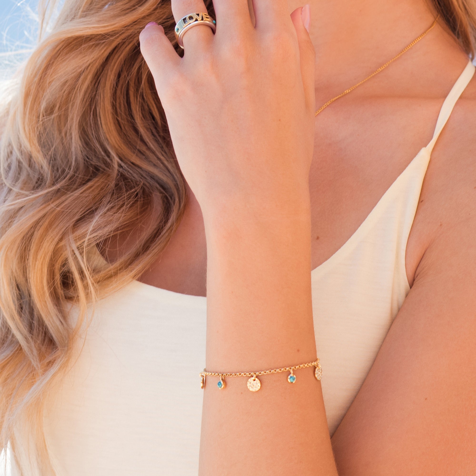 Gold charm bracelet wit gold hammered discs and turquoise charms