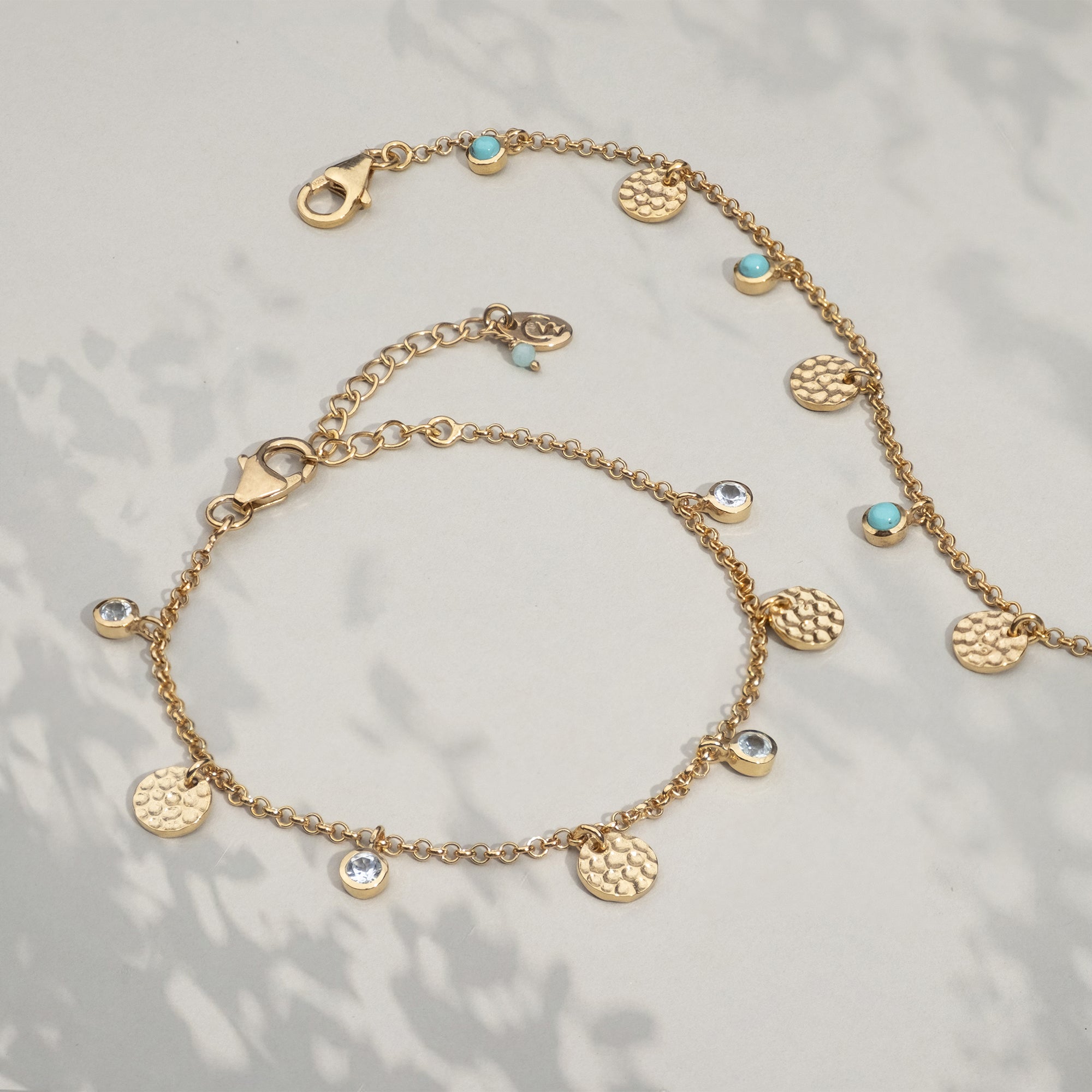 Gold bracelet with hammered discs and genuine blue topaz charms