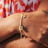 Gold vermeil charm bracelet on a wrist featuring genuine gemstones