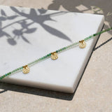 Necklace with green beads and gold hammered discs