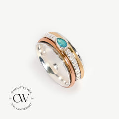 Mixed metal spinning ring with pariaba topaz gemstone